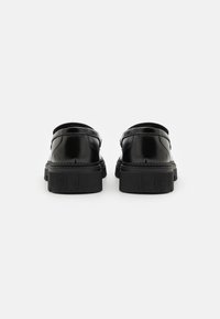 Black leather shoes with a shiny finish, rubber soles, and rounded backs. Features stitching detail along the seams and a modest design.