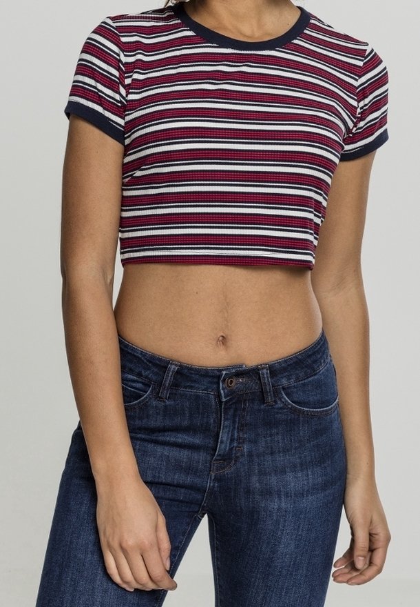 Camiseta recortada de canalé con rayas horizontales en rojo, blanco y azul marino. Presenta un cuello azul marino y mangas cortas. Combinada con jeans de un azul oscuro.