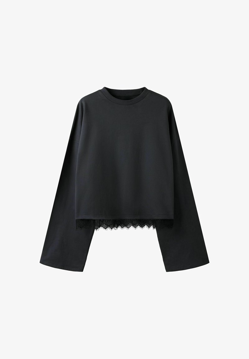 Fekete hosszú ujjú, rövidített felső széles ujjakkal és csipkés szegéllyel az alján, kerek nyakkivágással.