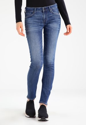 Jeans skinny azules de mezclilla, con un diseño clásico de cinco bolsillos, un ligero desgastado y un dobladillo que termina por encima del tobillo.