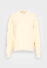 Jasnożółta bluza z okrągłym dekoltem, opuszczonymi ramionami, ściągaczami na mankietach oraz miękką, szczotkowaną teksturą. Klasyczny, swobodny krój.