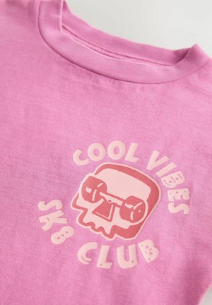 Heled roosa puuvillane T-särk, millel on graafiline logo skeletiga ja hantlitega, tekst ütleb "COOL VIBES SK8 CLUB", lihtne ümmargune kaelus.