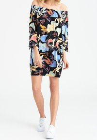 Robe fleurie à épaules dénudées avec un fond noir, des motifs floraux colorés en bleu, rose et jaune, manches trois quarts et coupe décontractée.