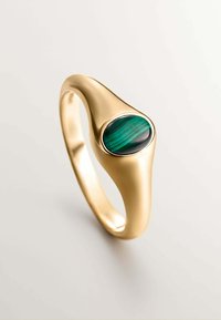 Anillo de oro con una banda lisa y curvada que presenta una piedra de malaquita ovalada, exhibiendo patrones de rayas verdes y negras. Acabado brillante.