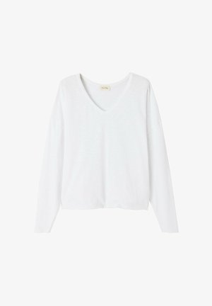 Valge pikkade varrukatega V-kaelusega topp, valmistatud kergest kangast. Omab lõdva lõiget, veidi langenud õlgade ja sirge äärega.