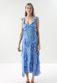 Flowy blue dress with ruffled accents, layered design, floral patterns, and a mid-length hem. Lightweight fabric, sleeveless style.