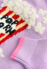 Hellblauer Pullover mit einem Popcorn-Motiv, einem rot-weiß gestreiften Eimer, flauschigen weißen Wolken und rosa akzentuierten Bündchen.
