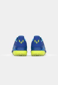 Blue athletic shoes with yellow accents. Features a textured upper, ribbed heel, and a grooved sole designed for traction.