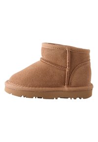 Hellbrauner Knöchelstiefel aus weichem Wildleder mit runder Zehenpartie, genähten Details und einer strukturierten Gummisohle mit niedrigem Profil.