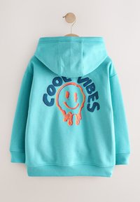 Türkisfarbener Hoodie mit einer Fronttasche und eingesticktem "COOL VIBES" Schriftzug, versehen mit einem schmelzenden Smiley-Grafik in lebendigen Farben.