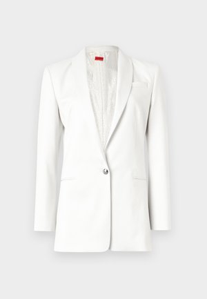 Fehér blézer, egygombos záródással, kerekített hajtókákkal és finom textúrával. Zsebkendő részletekkel és selyemhez hasonló bélésbéléssel rendelkezik.