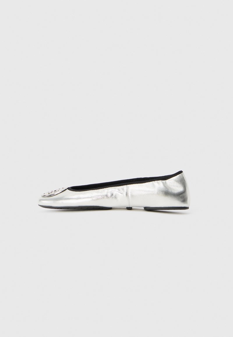 Ballerines plates en cuir argenté avec un bout rond, doublure intérieure noire, et embellissements décoratifs au niveau de la pointe. Semelle plate.