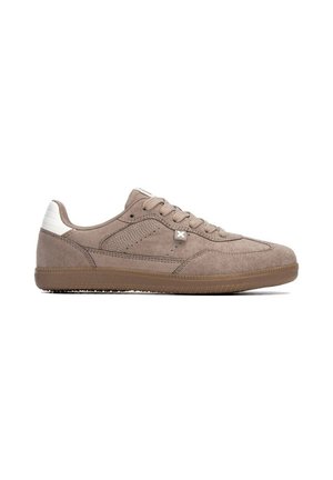 Zapatilla baja de ante marrón con cordones delanteros, suela de goma, parche blanco en el talón y pequeño detalle cosido en el lateral sobre fondo blanco.