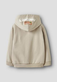 Sudadera beige con un bolsillo tipo canguro, puños y dobladillo acanalados. Presenta un logo blanco en la capucha y una etiqueta beige con un acento verde.