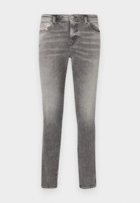 Grey denim skinny jeans with five pockets, faded wash, and rivet detailing. Features a button closure and belt loops along the waistband.