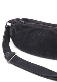 Black fabric shoulder bag with a zip closure. Textured surface, adjustable strap, and subtle logo detail on the front.