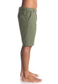 Shorts vert olive en tissu mélangé coton, arrivant au genou, avec poches avant et une poche arrière dotée d'une étiquette. Texture lisse, design décontracté.