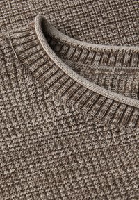Hnědý pletený svetr s texturovaným vzorem, žebrovaným límcem a kontrastním světlým lemováním kolem výstřihu.