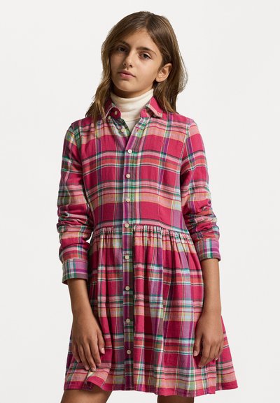 Rdeča karirana obleka z gumbi spredaj, dolgimi rokavi in razširjenim krilom. V vzorcu so kontrastne zelene in rumene črte.