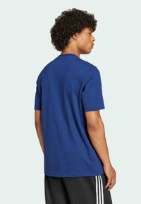 Navyblauw katoenen t-shirt met korte mouwen en een ronde hals, met een gladde textuur en een klassieke pasvorm, gedragen met zwarte sportbroeken.