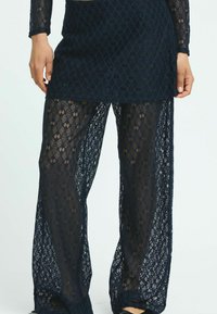 Navy lacebyxor med vid bendesign, intrikata diamantmönster, genomskinlig textur och elastisk midja för komfort.