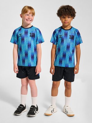 Dwoje dzieci w pasujących niebiesko-czarnych pasiastych koszulkach sportowych i czarnych szortach stojących obok siebie na białym tle.