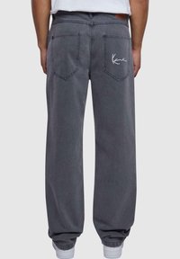 Jeans in denim grigio con una vestibilità comoda, dotati di due tasche posteriori e dettaglio del logo ricamato bianco sopra la tasca destra.