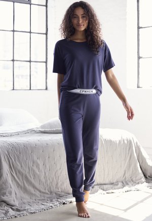 Navy loungewear set made of soft fabric, featuring a relaxed-fit T-shirt and tapered pants with a white branded waistband.