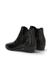 Botas de piel negras hasta el tobillo con tacones bajos en bloque, con patrones decorativos texturizados y con tachuelas en los laterales y la parte trasera.