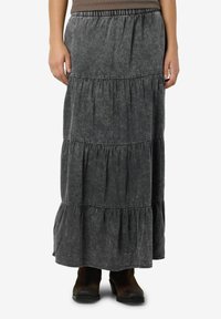 Ilgas, sluoksniuotas pilkas maxi sijonas su elastinga juosta ir minkšta, tekstūrine medžiaga. Apačioje esantys sluoksniuoti volanai suteikia apimties. Derinamas su tamsiais batais.
