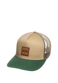 Gorra beige con visera verde, parte trasera de malla. Cuenta con un parche rectangular de cuero marrón con la marca en el frente. Diseño estructurado y clásico.