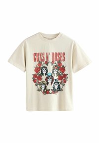Krémové bavlněné tričko s centrálním grafickým motivem lebek obklopených červenými růžemi a nápisem "GUNS N' ROSES" tučně červenou barvou.