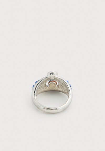 Ασημένιο δαχτυλίδι με μπλε πέτρες, στρογγυλεμένη ταινία και περίπλοκη υφή στο εσωτερικό. Ομαλή εξωτερική πλευρά με γυαλιστερό φινίρισμα.