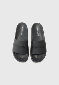 Ciabatte nere con una fascia testurizzata con il logo "JACK&JONES" in rilievo. Realizzate in materiale morbido e resistente con una suola liscia.