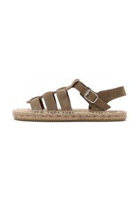 Sandalo in suede marrone con tre cinturini orizzontali, fibbia regolabile e suola intrecciata simile al giunco. Design piatto con accenti testurizzati.