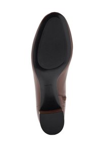 Suela de zapato de cuero marrón con una textura suave, forma ligeramente curvada, que presenta un patrón acanalado para el agarre y una punta redondeada.