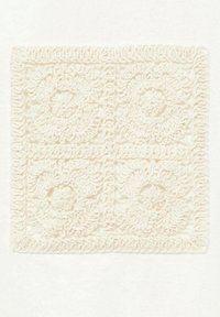 Carré en crochet couleur crème avec des motifs floraux, présentant des motifs complexes, une texture en relief et des bords dessinés. Convient pour un usage décoratif.