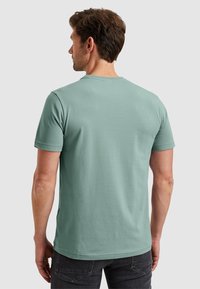 Mint green short-sleeve t-shirt made of cotton. Classic crew neckline and a smooth texture. The back shows clean stitching details.