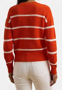 Randig stickad tröja i stark orange och vit. Ribbad textur med långa ärmar och en kort passform. Vita ränder över torso.