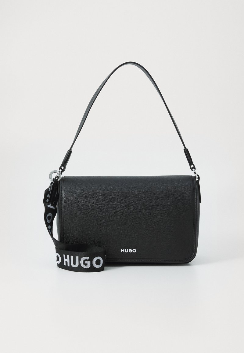 Bolsa de couro preta com uma textura suave, formato retangular, alça superior e uma alça com marca que apresenta letras brancas.