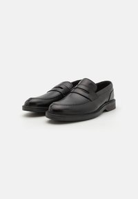 Black leather loafers with a smooth finish, featuring decorative stitching and a double strap accent across the vamp.
