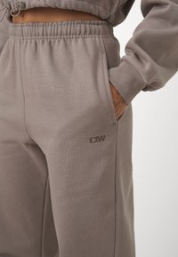 Grijze joggingbroek van zachte stof, met een elastische tailleband, zijzakken en een subtiele logoafdruk op het been.