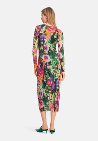 Langes, enganliegendes Kleid mit einem bunten Blumenmuster auf einem dunklen Hintergrund. Hergestellt aus einem dehnbaren Stoff mit langen Ärmeln und rundem Ausschnitt.
