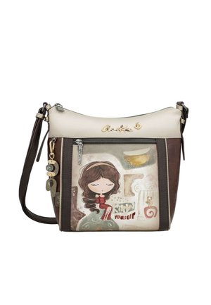 Borsa a tracolla con pannelli beige e marroni, illustrazione di ragazza in stile cartone animato, tasca frontale con cerniera e portachiavi decorativo su tracolla scura.