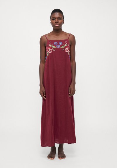 Robe maxi bourgogne avec des bretelles spaghetti, ornée de broderies florales colorées autour du décolleté. Tissu doux avec un design fluide.