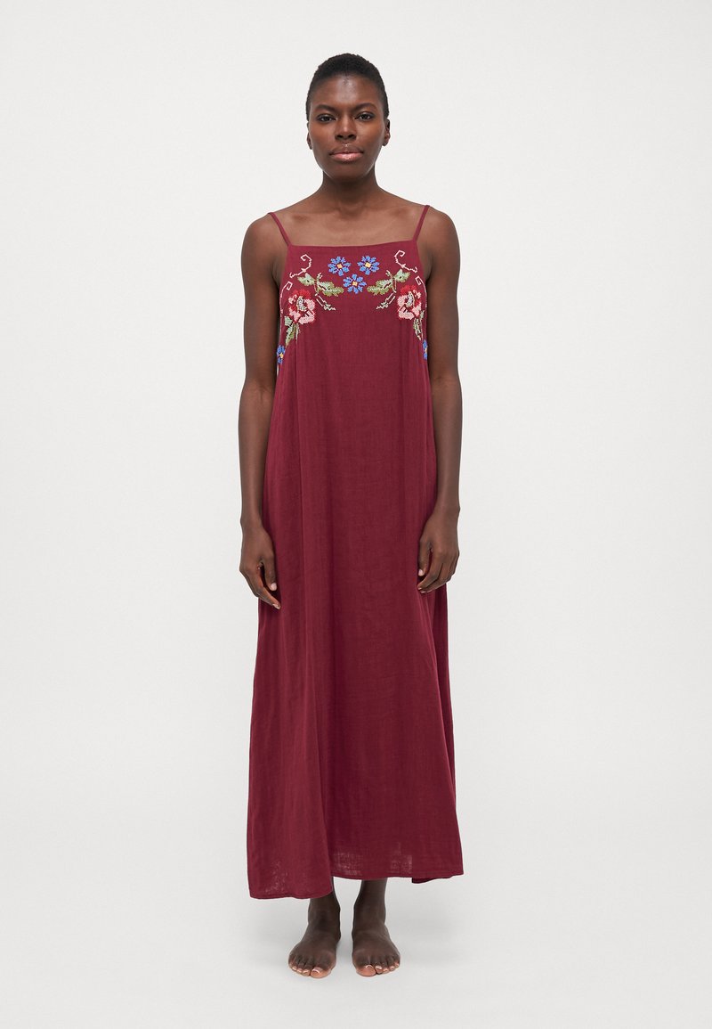 Vestito lungo bordeaux con spalline sottili, caratterizzato da un ricamo floreale colorato intorno al colletto. Tessuto morbido con un design fluido.