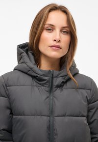 Šedá vatovaná bunda s kapucňou, s predným zipsom, prešívaným panelovým dizajnom a hladkou matnou textúrou.