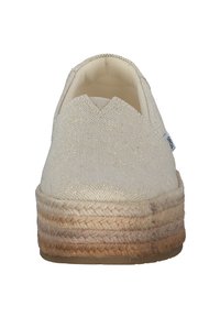 Beige instap schoen met een geweven touwzool en lichte glansstof, gezien van de voorkant, met een klein zijlabel.