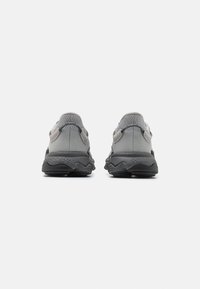 Gray athletic sneakers featuring a mesh upper, textured accents, a chunky black sole, and a rounded heel. Back view shows dual-tone design.