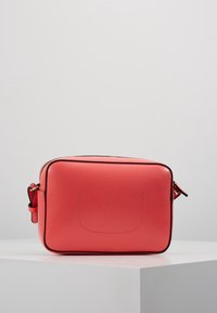 Różowa torba na ramię w odcieniu koralowym, wykonana z teksturowanej skóry, z zamkiem błyskawicznym, prostokątnym kształtem i czarnymi detalami na krawędziach. W zestawie regulowany pasek na ramię.